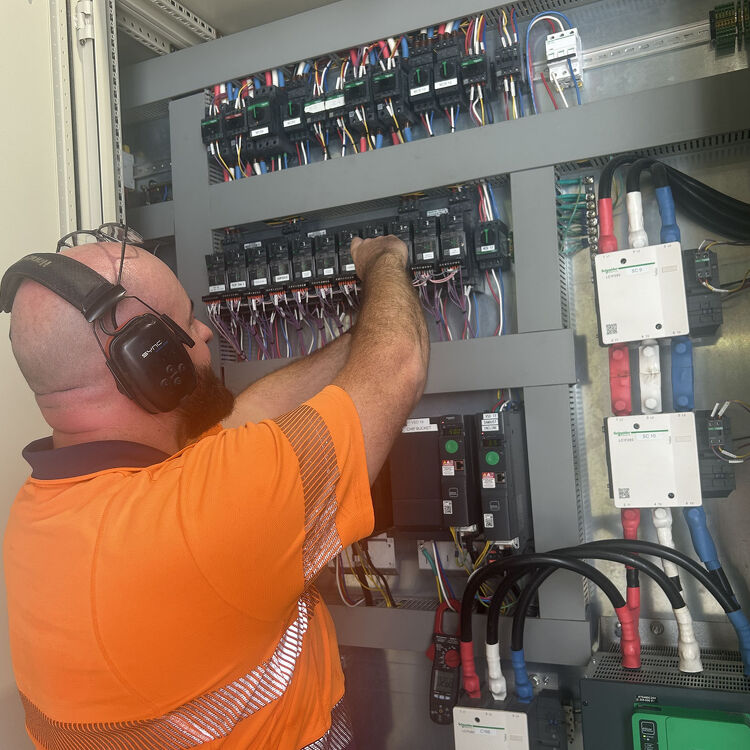 Electrician performing preventive maintenance on switchboard